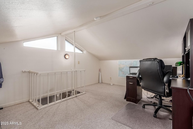 carpeted home office featuring vaulted ceiling with beams and a textured ceiling