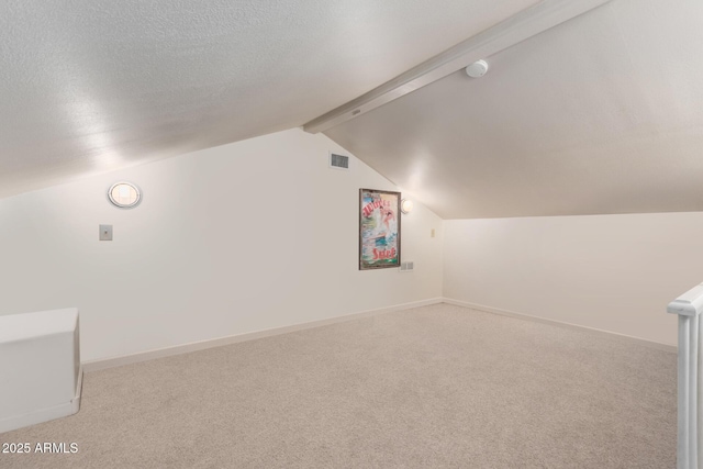 bonus room with light carpet, vaulted ceiling with beams, and a textured ceiling