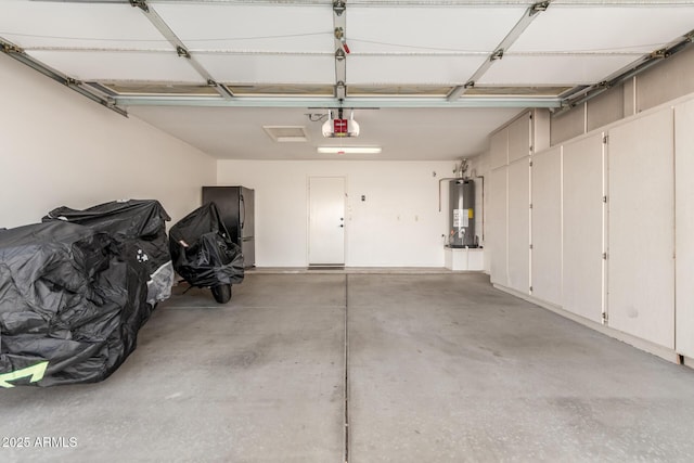 garage featuring black fridge, a garage door opener, and gas water heater