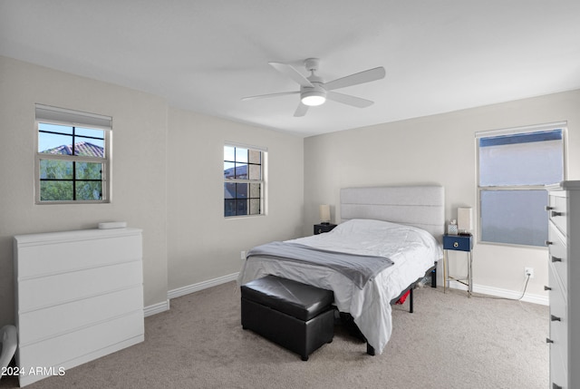 carpeted bedroom with multiple windows and ceiling fan