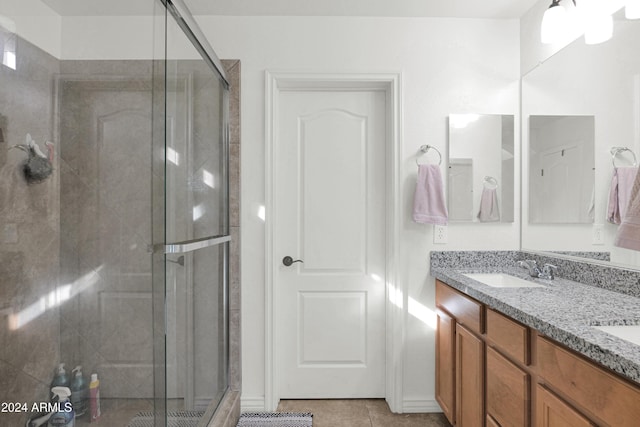 bathroom featuring vanity, tile patterned floors, and a shower with door