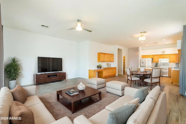 living room featuring light hardwood / wood-style flooring and ceiling fan