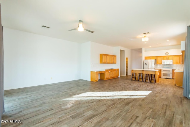 unfurnished living room with ceiling fan and light hardwood / wood-style flooring