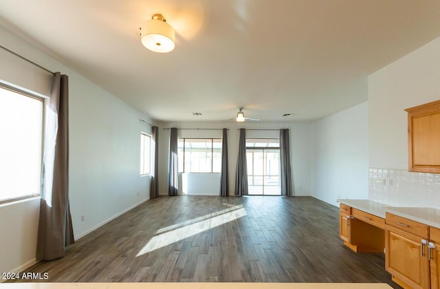 interior space featuring ceiling fan, dark hardwood / wood-style flooring, built in desk, and tasteful backsplash