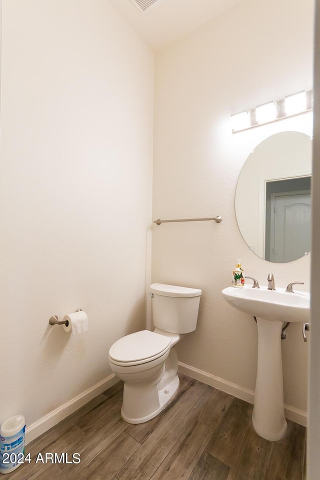 bathroom with wood-type flooring and toilet