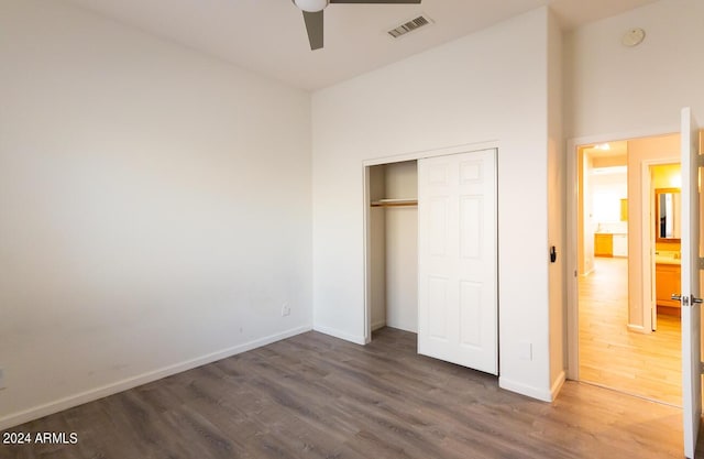 unfurnished bedroom with dark hardwood / wood-style flooring, ceiling fan, and a closet