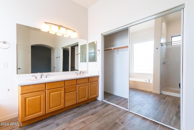 bathroom with separate shower and tub, vanity, and wood-type flooring