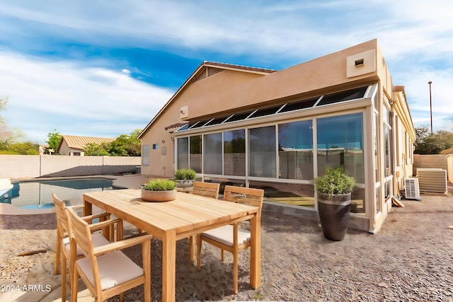 rear view of house featuring a fenced in pool