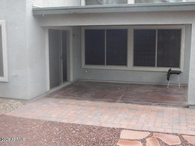 doorway to property with a patio area and stucco siding