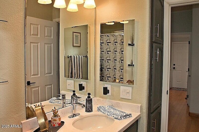 1181 S Cherokee Dr, Show Low, AZ 85901 - bathroom with a textured wall, vanity, curtained shower, and wood finished floors