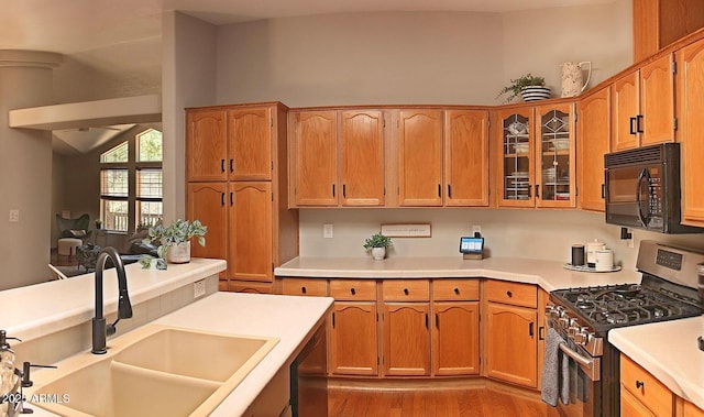 1181 S Cherokee Dr, Show Low, AZ 85901 - kitchen featuring stainless steel appliances, a sink, glass insert cabinets, light countertops, and light wood-type flooring