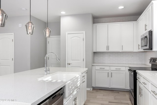 kitchen featuring backsplash, light hardwood / wood-style flooring, light stone countertops, white cabinetry, and stainless steel appliances