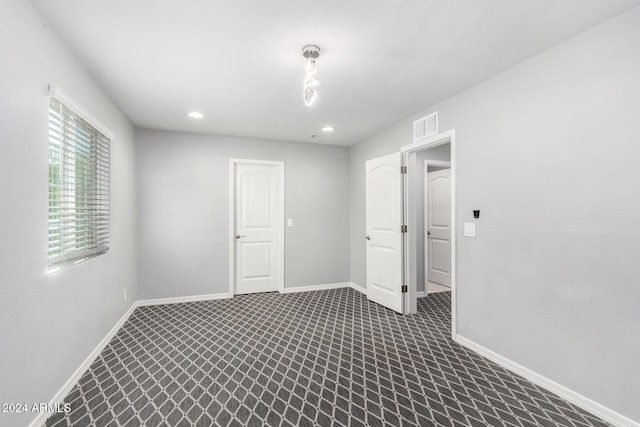 unfurnished room with dark carpet