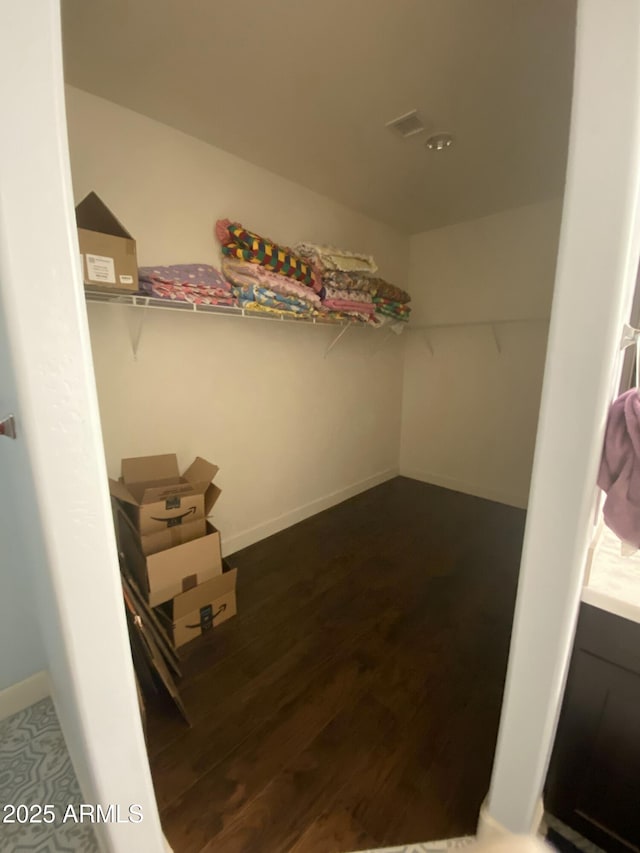 walk in closet featuring dark wood-type flooring