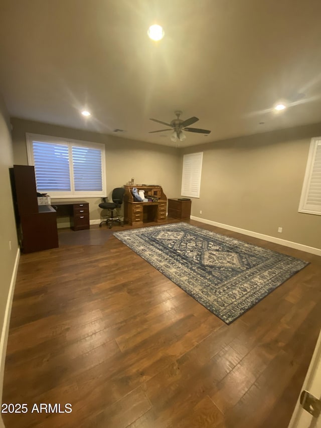 living area with dark wood-type flooring and ceiling fan