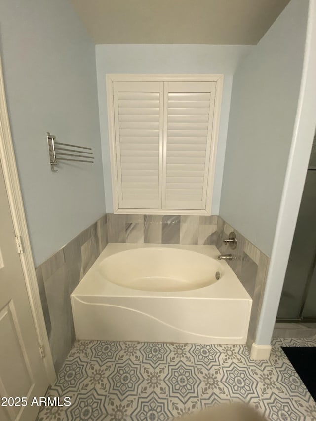 bathroom with tile patterned flooring, a bathtub, and tile walls