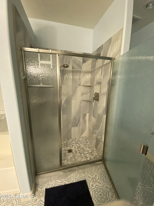 bathroom with tile patterned floors and walk in shower