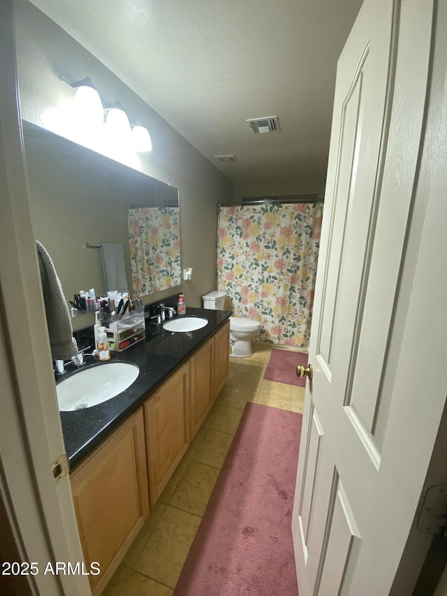 bathroom with tile patterned flooring, vanity, and toilet