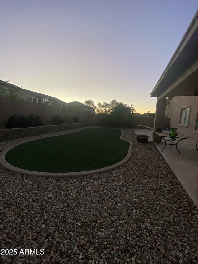 yard at dusk with a patio area