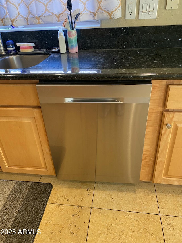 room details featuring sink, stainless steel dishwasher, dark stone counters, and light brown cabinets