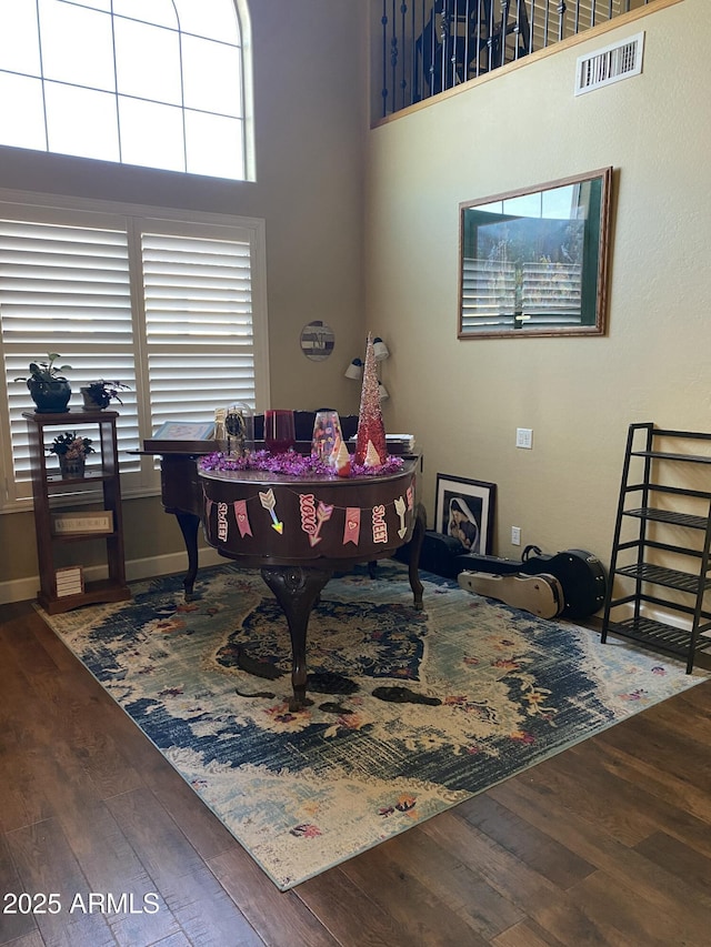 home office with hardwood / wood-style floors and a high ceiling