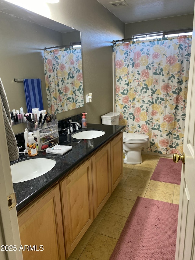 bathroom featuring vanity, tile patterned floors, and toilet