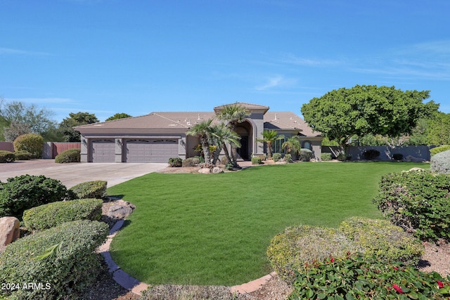 mediterranean / spanish-style house featuring a front yard and a garage