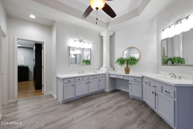 bathroom featuring hardwood / wood-style floors, ceiling fan, a tray ceiling, decorative columns, and vanity