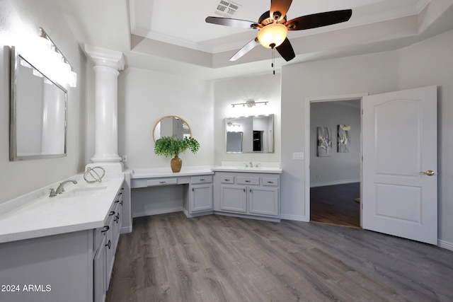 bathroom with decorative columns, a raised ceiling, wood-type flooring, and ornamental molding