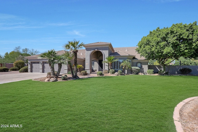 mediterranean / spanish-style house featuring a front yard and a garage