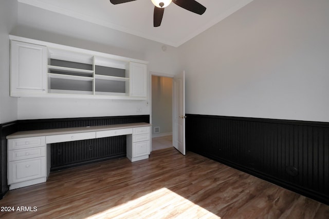 unfurnished office featuring ornamental molding, dark hardwood / wood-style floors, built in desk, and ceiling fan