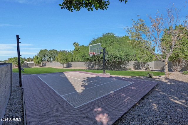 view of basketball court with a yard