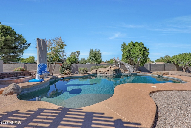 view of swimming pool with a water slide and a patio area