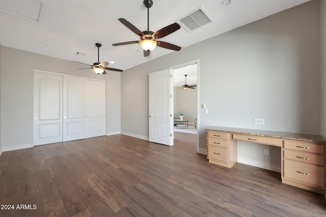 interior space with built in desk, dark wood-type flooring, and ceiling fan