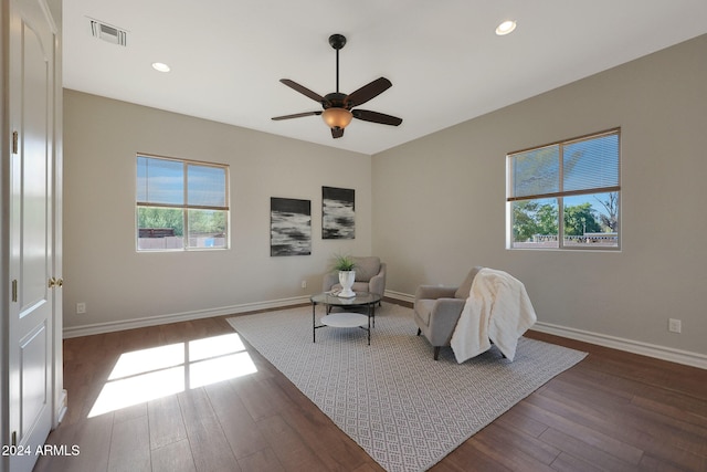 living area with dark wood-type flooring and ceiling fan