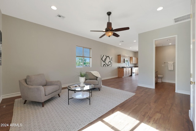 living room with ceiling fan and dark hardwood / wood-style flooring