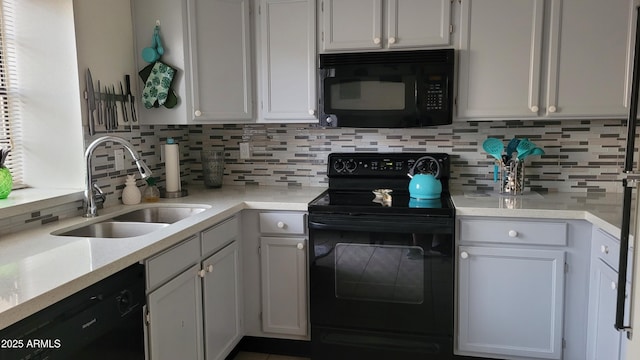 kitchen with white cabinetry, sink, tasteful backsplash, and black appliances