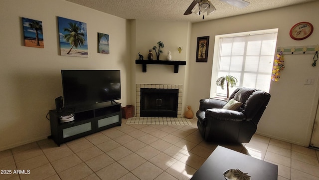 tiled living room featuring ceiling fan and a textured ceiling