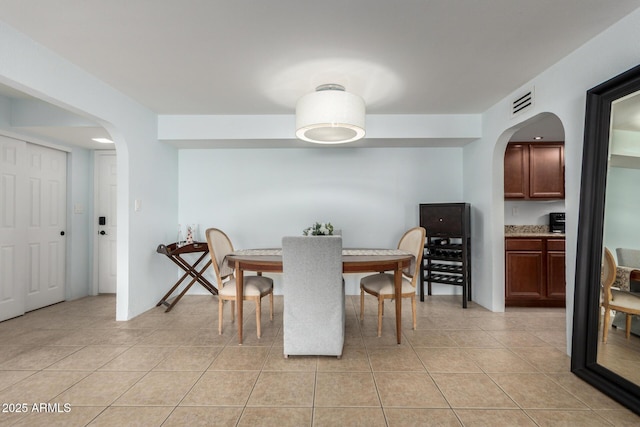 8500 E Indian School Rd Unit 233, Scottsdale, AZ 85251 - dining room with arched walkways and light tile patterned floors