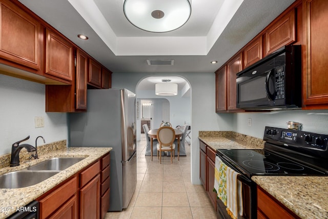 8500 E Indian School Rd Unit 233, Scottsdale, AZ 85251 - kitchen with black appliances, a sink, arched walkways, light tile patterned flooring, and a raised ceiling