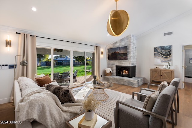 living room featuring crown molding, a fireplace, wood-type flooring, and lofted ceiling