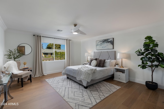 bedroom featuring ceiling fan, crown molding, and light hardwood / wood-style floors