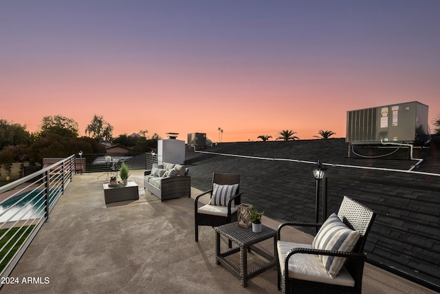 patio terrace at dusk with an outdoor living space, a balcony, and central air condition unit