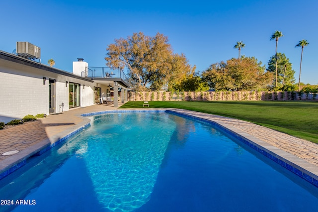 view of pool featuring central air condition unit, ceiling fan, a patio area, and a lawn