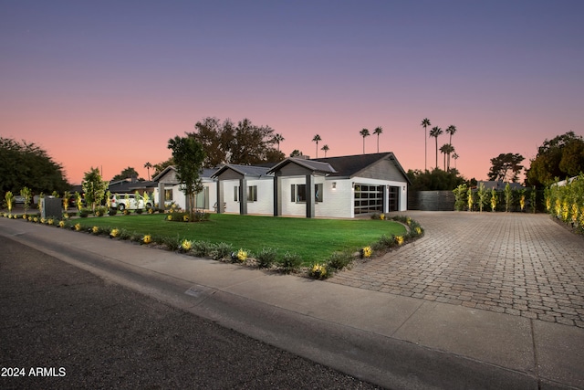 ranch-style house featuring a garage and a yard