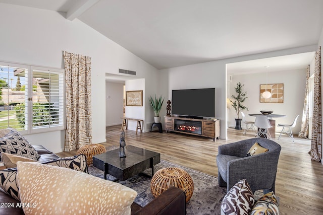 living room featuring high vaulted ceiling, visible vents, beamed ceiling, and wood finished floors