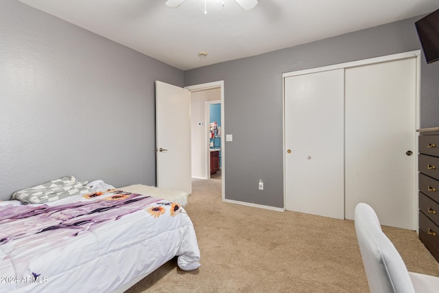 bedroom with a closet, light colored carpet, and ceiling fan