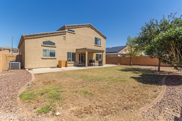 rear view of house featuring a lawn, a patio area, and central AC unit