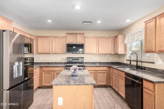 kitchen featuring light brown cabinets, a center island, stainless steel appliances, and sink