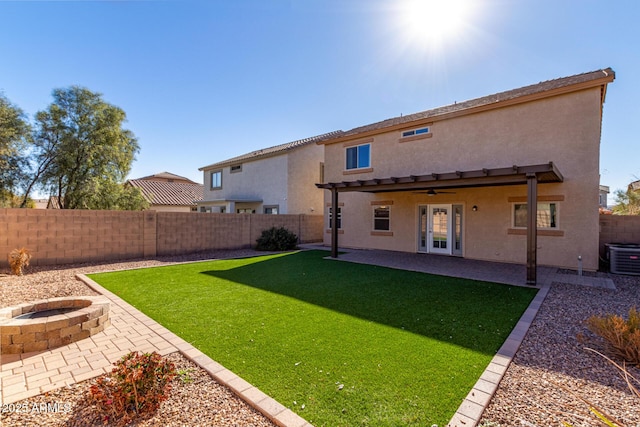 rear view of house with a fire pit, french doors, cooling unit, a yard, and a patio area